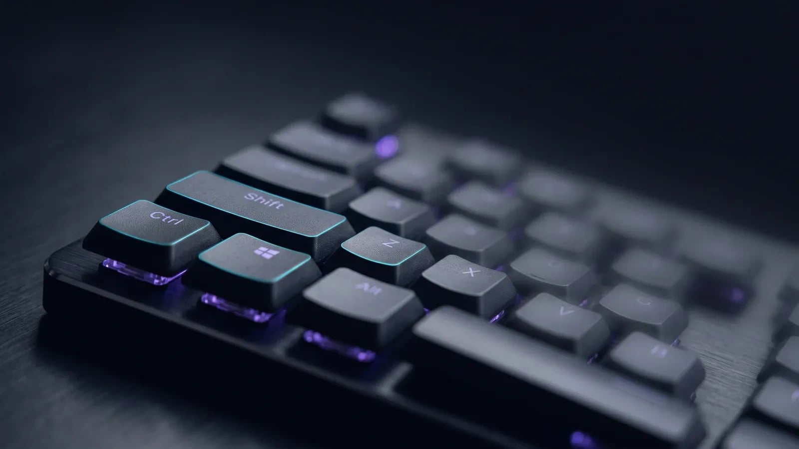 Gros plan sur les touches Ctrl, Maj et Windows d'un clavier retroeclaire en violet